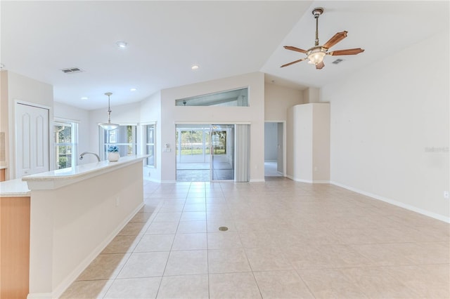 interior space with light stone countertops, ceiling fan, hanging light fixtures, lofted ceiling, and light tile patterned floors