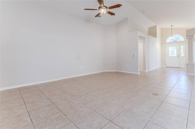 empty room with ceiling fan, light tile patterned floors, and vaulted ceiling