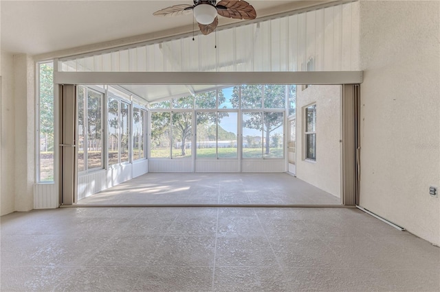 unfurnished sunroom featuring ceiling fan and vaulted ceiling