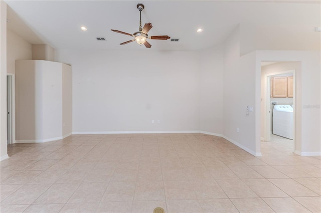 tiled spare room featuring ceiling fan and washer / dryer