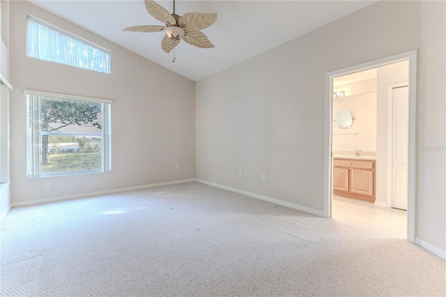 carpeted spare room featuring ceiling fan, sink, and lofted ceiling