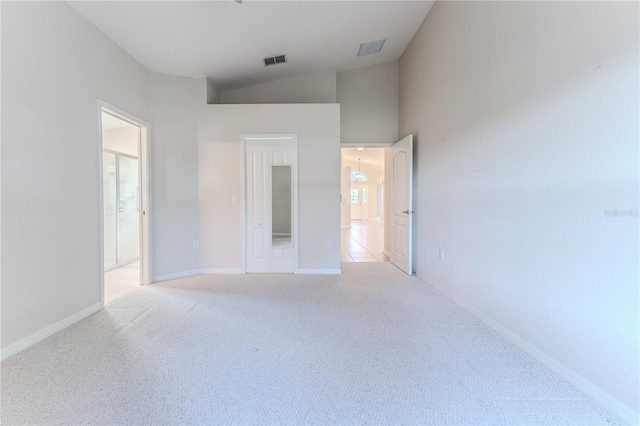 carpeted empty room featuring high vaulted ceiling