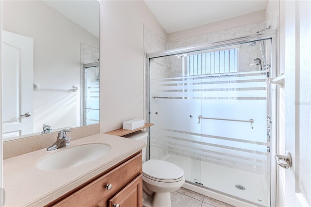 bathroom featuring vanity, vaulted ceiling, tile patterned flooring, toilet, and a shower with shower door