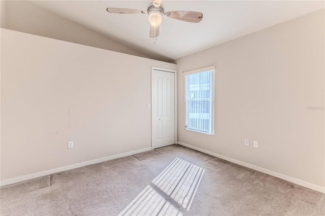 carpeted empty room featuring ceiling fan and lofted ceiling