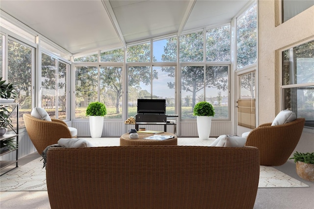 sunroom / solarium with a healthy amount of sunlight and vaulted ceiling