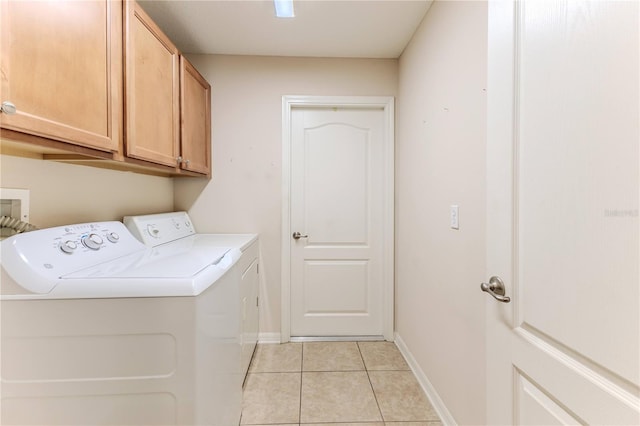 washroom with washing machine and clothes dryer, light tile patterned floors, and cabinets