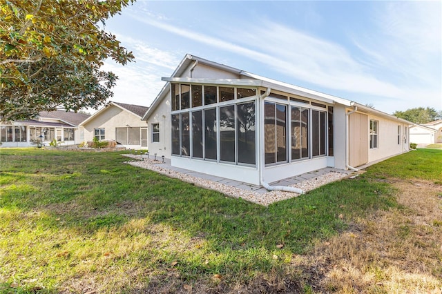 back of property with a sunroom and a yard