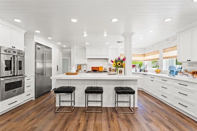 kitchen featuring appliances with stainless steel finishes, dark hardwood / wood-style floors, and white cabinetry