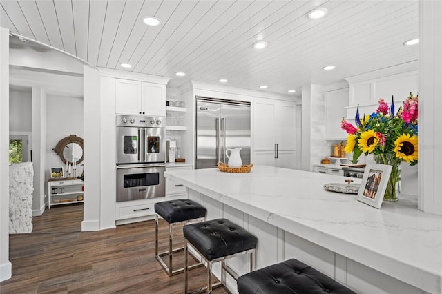 kitchen featuring white cabinetry, light stone countertops, dark wood-type flooring, stainless steel appliances, and wood ceiling