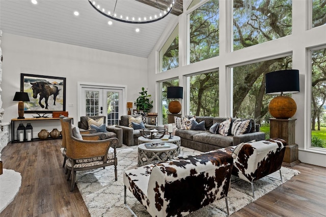 sunroom with french doors, a healthy amount of sunlight, a notable chandelier, and wood ceiling