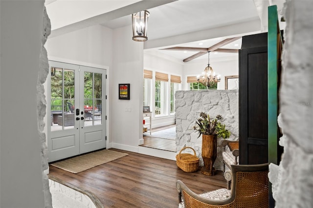 foyer with beam ceiling, french doors, a notable chandelier, and wood-type flooring