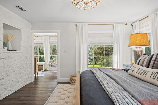 bedroom with dark wood-type flooring and a notable chandelier