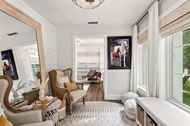 sitting room with wood-type flooring and an inviting chandelier