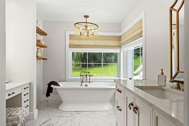 bathroom with a bathing tub, vanity, and a notable chandelier