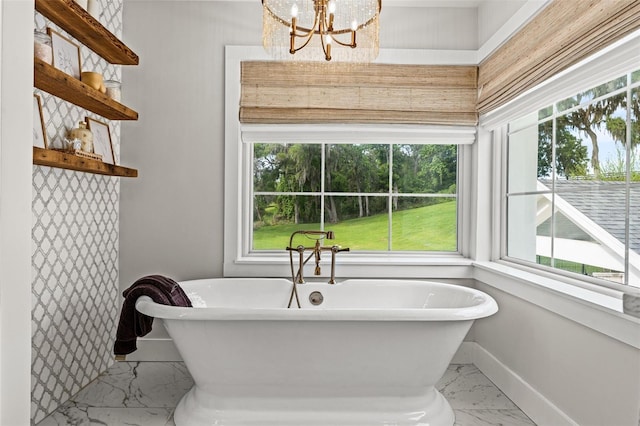 bathroom featuring a bathing tub, a wealth of natural light, and an inviting chandelier