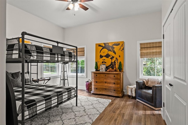 bedroom with multiple windows, ceiling fan, and hardwood / wood-style floors