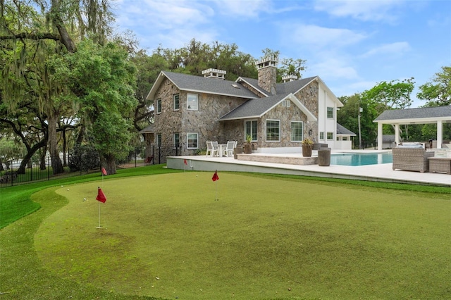 rear view of house featuring a patio area and a fenced in pool