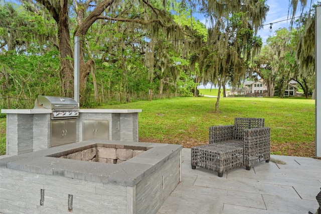 view of patio / terrace with an outdoor kitchen, area for grilling, and a fire pit