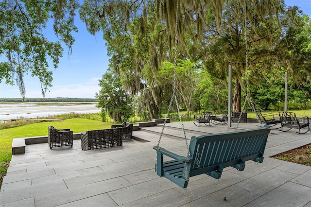 view of home's community featuring a lawn, a water view, an outdoor hangout area, and a patio