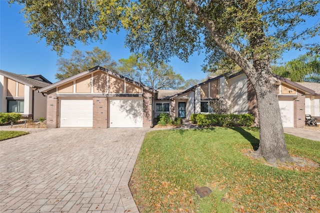 mid-century home with a front yard, brick siding, decorative driveway, and an attached garage