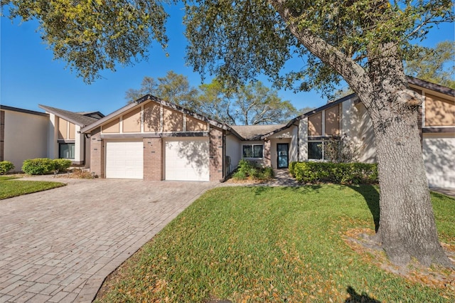 mid-century home with an attached garage, driveway, a front lawn, and brick siding