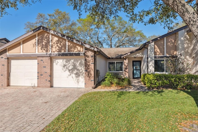 mid-century home with brick siding, a front lawn, a garage, and stucco siding