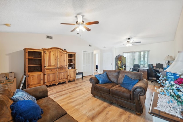 living room with light wood-style flooring, ceiling fan, lofted ceiling, and visible vents