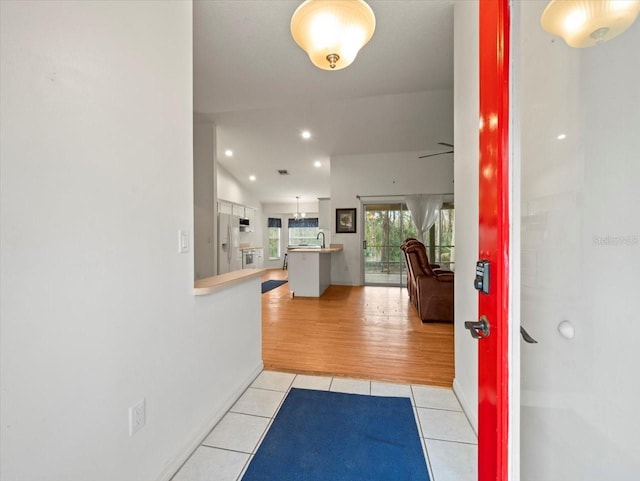 entrance foyer with ceiling fan, light tile patterned flooring, and lofted ceiling