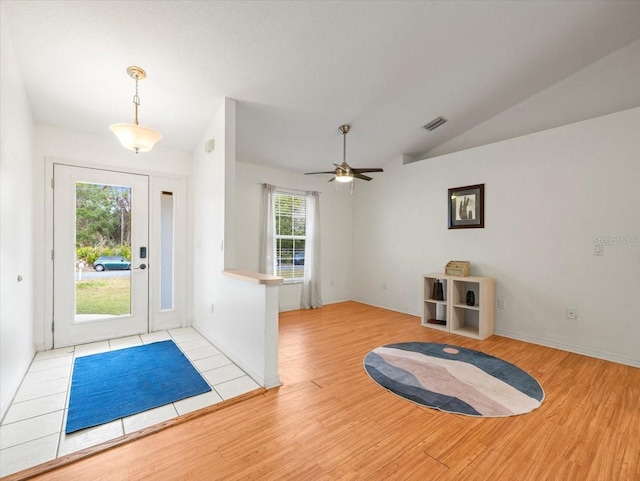 entryway with ceiling fan, light hardwood / wood-style floors, a healthy amount of sunlight, and vaulted ceiling