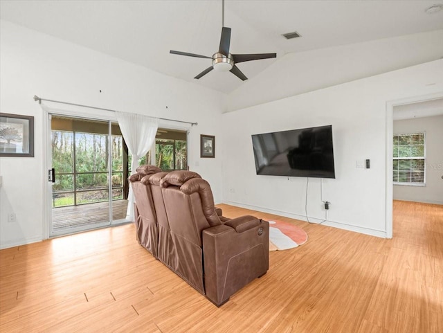 living room with light wood-type flooring, vaulted ceiling, and ceiling fan