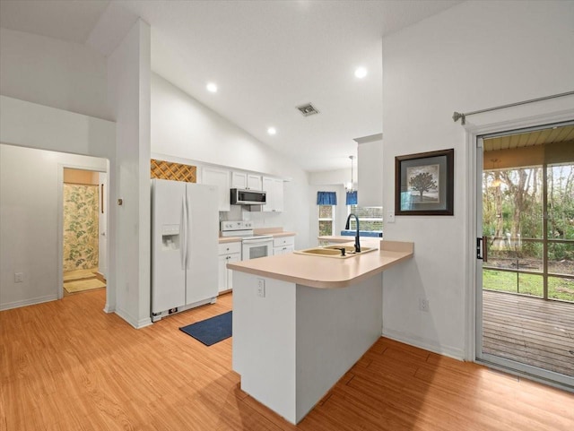 kitchen with sink, high vaulted ceiling, kitchen peninsula, white appliances, and white cabinets