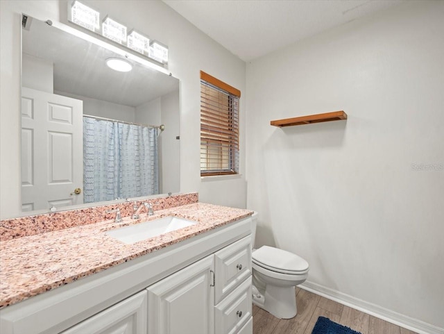 bathroom featuring wood-type flooring, vanity, toilet, and curtained shower