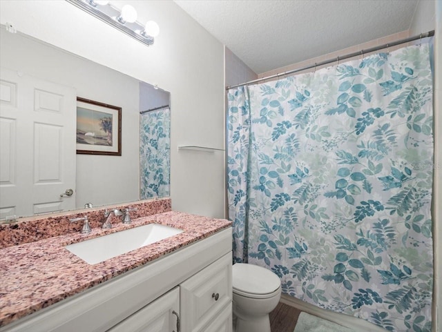 bathroom featuring vanity, toilet, and a textured ceiling