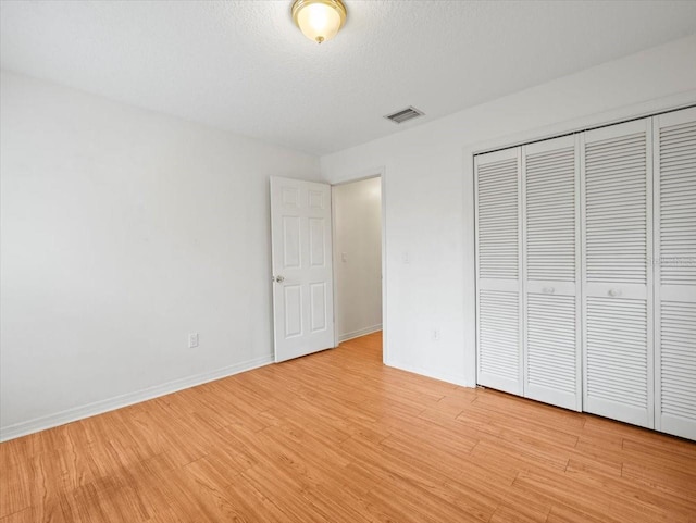 unfurnished bedroom featuring a closet and light hardwood / wood-style flooring