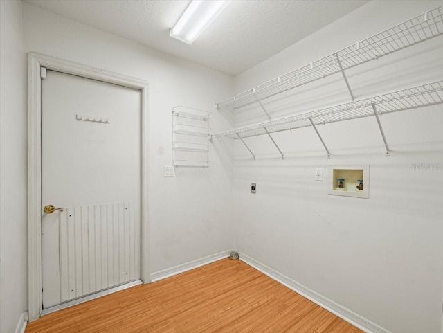 laundry room with hookup for an electric dryer, hookup for a washing machine, radiator heating unit, and hardwood / wood-style floors