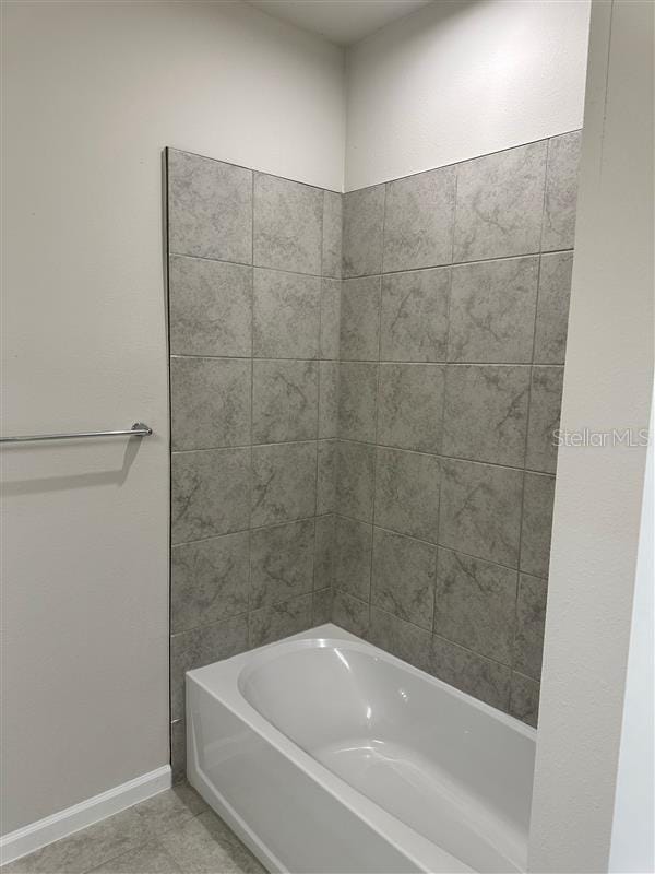 bathroom featuring shower / bathtub combination and tile patterned flooring