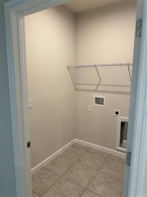 laundry area with light tile patterned floors, washer hookup, and electric dryer hookup