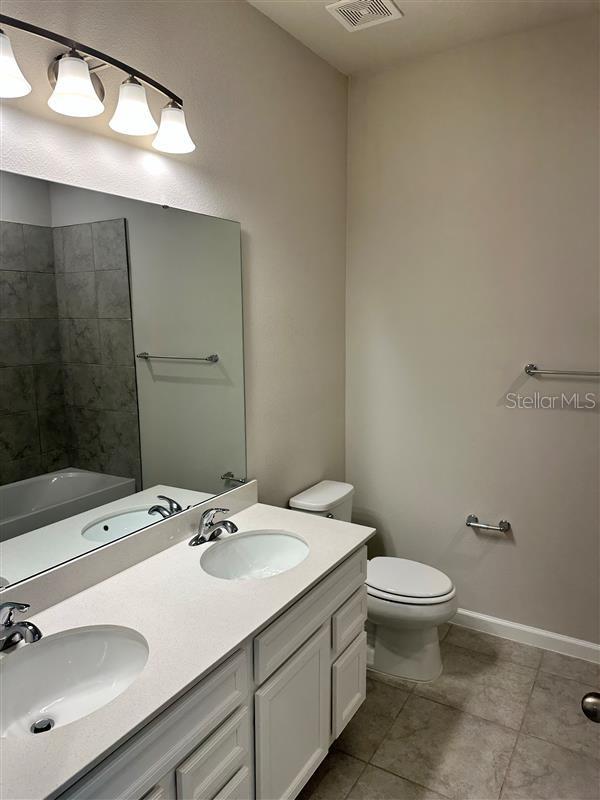 full bathroom with toilet, tile patterned floors, vanity, and bathtub / shower combination