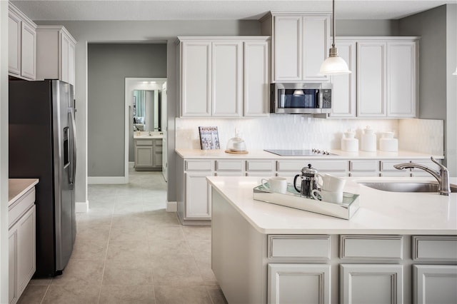 kitchen with sink, white cabinets, decorative light fixtures, and appliances with stainless steel finishes