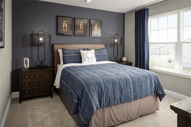 bedroom with a textured ceiling and light carpet