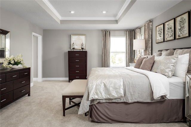 bedroom with light carpet, a tray ceiling, and ornamental molding