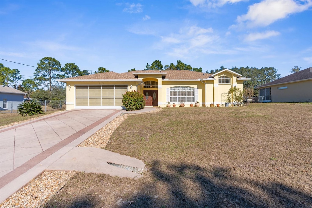 ranch-style home with a front yard and a garage