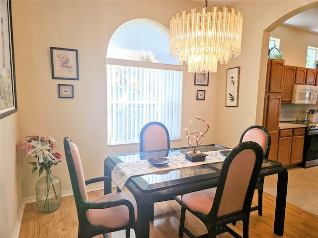 dining room with light wood-type flooring and an inviting chandelier