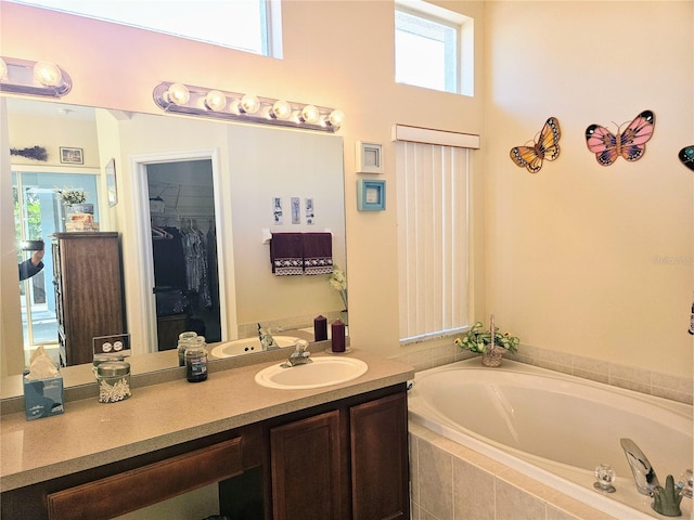 bathroom featuring vanity and a relaxing tiled tub