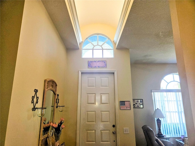 entryway featuring a textured ceiling and vaulted ceiling