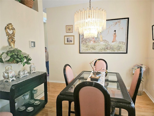 dining area featuring light hardwood / wood-style floors and a notable chandelier