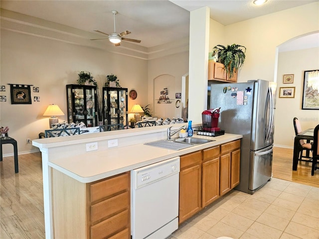 kitchen with white dishwasher, sink, ceiling fan, stainless steel fridge, and kitchen peninsula