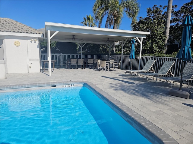 view of swimming pool featuring ceiling fan and a patio