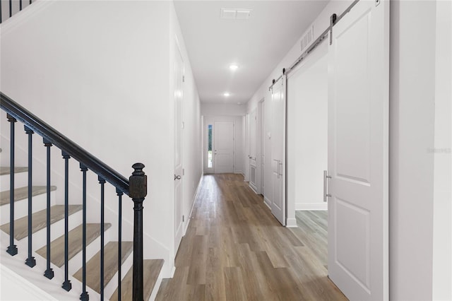 hall featuring a barn door and light wood-type flooring