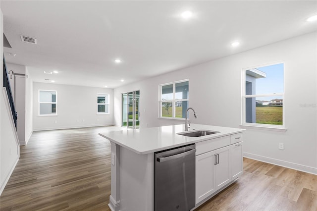 kitchen featuring dishwasher, sink, an island with sink, light hardwood / wood-style floors, and white cabinetry